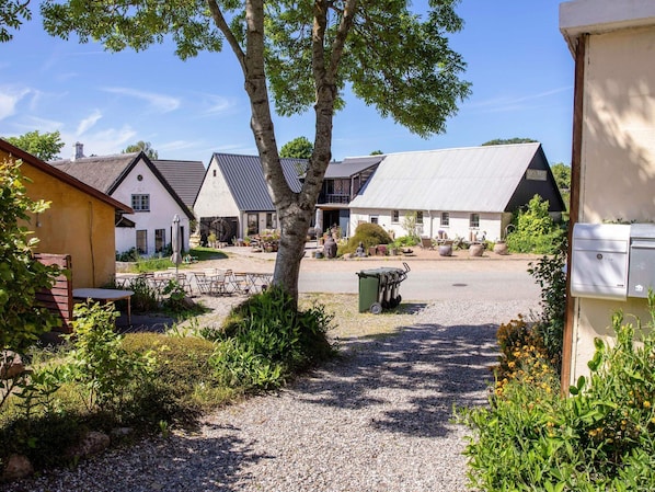 A rural setting with traditional buildings, a gravel path, and greenery. - 4 Star Holiday Home in Samso (Samsø)