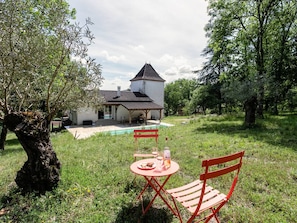 A rustic house with a covered patio, a swimming pool, and a red table with chairs. - House with AC, private pool - 6 guests (Lamagdelaine)