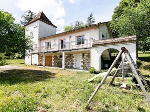 A two-story house with a balcony, stone facade, and a staircase leading to an upper level. - House with AC, private pool - 6 guests (Lamagdelaine)