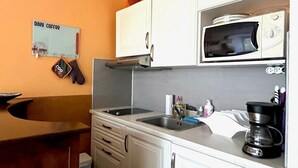 Une cuisine équipée d’un four à micro-ondes, d’un évier et de placards.