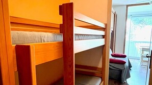 Une chambre avec des lits superposés donnant sur l’extérieur.