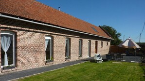 Ein Backsteinhaus mit Satteldach, befestigter Auffahrt und Rasengrundstück.