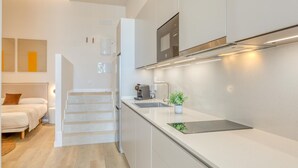 A modern kitchen with a built-in oven, a coffee machine, and a small plant on the counter. - Modern studio, port view - 2 guests (Estepona)