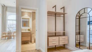A modern bedroom with a bed, a walk-in closet, and a dining area with a table and chairs. - Modern studio, port view - 2 guests (Estepona)