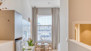 A modern kitchen with a dining area, large window, and a view of the street. - Modern studio, port view - 2 guests (Estepona)