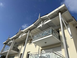 A multi-story building with balconies, a flat roof, and a clear sky. - Apartment with pets - 4 guests (Moliets-et-Maa)