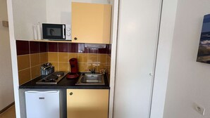 A compact kitchen with a microwave, a coffee maker, and a refrigerator. - Studio in Cap d'Agde center - 2 guests (Cap d'Agde)