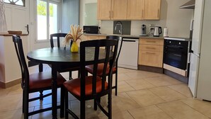 A modern kitchen with wooden cabinets, a dishwasher, and a built-in oven. - Unique house for car enthusiasts (Chenicourt)