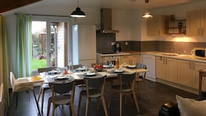 A modern kitchen with a dining area, a high ceiling with exposed beams, and a view of the outdoors. - Charming cottage by Belgian border - 7 guests (SAINT WAAST LA VALLEE)