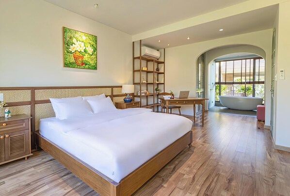 A bedroom with a large bed, a desk, a bookshelf, and a bathtub. - Hometown Pinky 3 BRS Pool Villa Hoi An (Hoi An Tay)