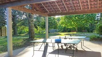An outdoor patio with a pergola, a table, and chairs.