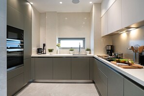 Eine moderne Küche mit eingebauten Geräten, einem Fenster über der Spüle und einer Arbeitsplatte mit verschiedenen Küchenutensilien.
