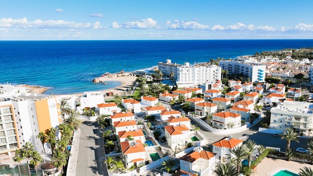 A coastal resort with white buildings, red roofs, and a beach. - Villa Amarilia - 100m from Pernera Beach (Pernera)