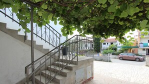 A staircase with metal railings, a stone wall, and a car parked on the street. - Rooms and Studio Salvi (Rovinj)