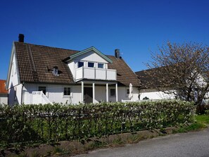 A two-story house with a brown tiled roof, white exterior walls, and a front porch. - 4 Star Holiday Home in Kungshamn (Kungshamn)