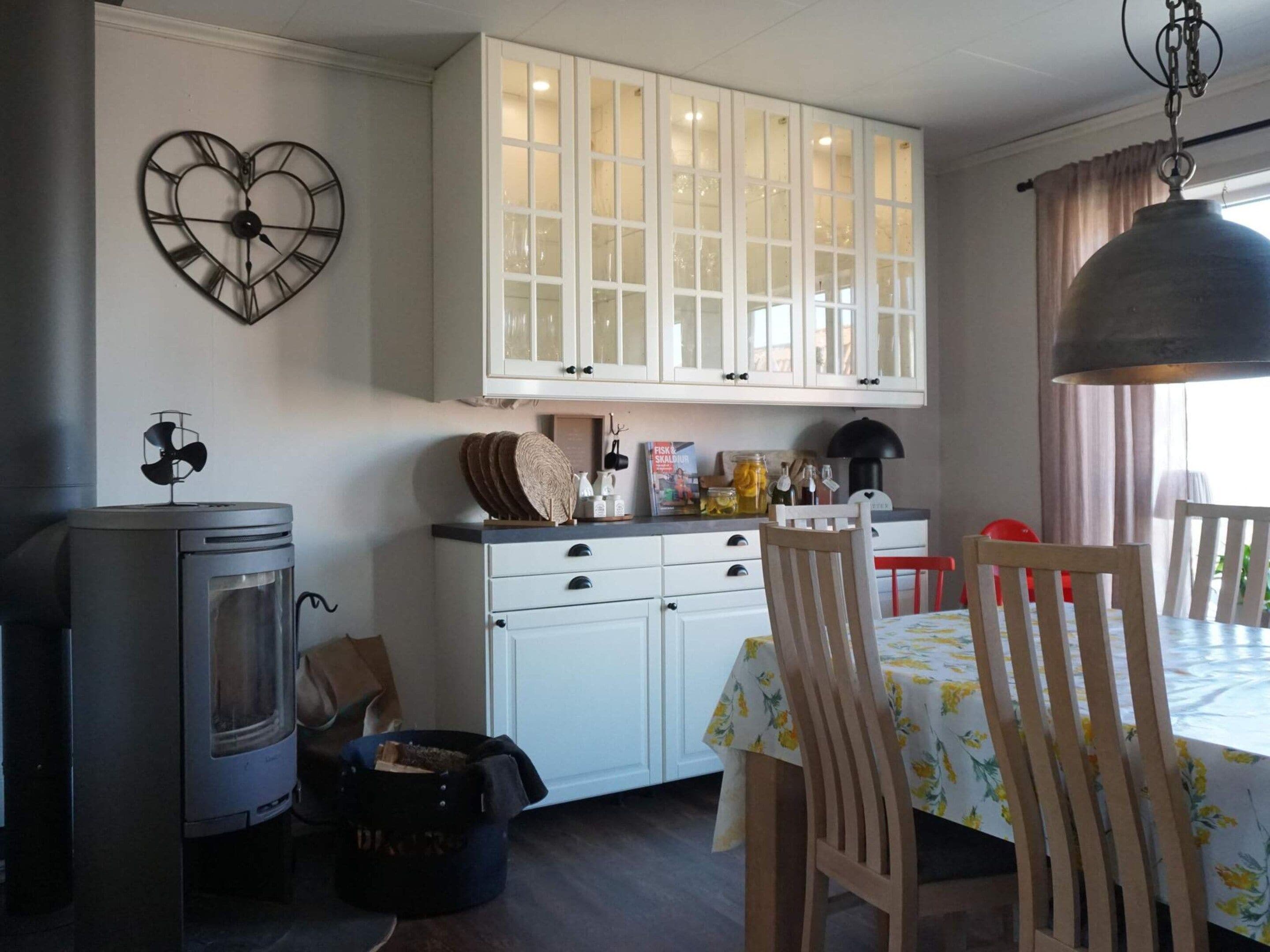 A kitchen with a stove, cabinets, and a dining table with chairs.