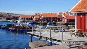 A harbor with red buildings, boats, and a wooden dock. - 4 Star Holiday Home in Kungshamn (Kungshamn)