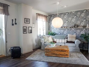 A living room with a grey sofa, a wooden coffee table, and a floral wallpaper. - 4 Star Holiday Home in Kungshamn (Kungshamn)