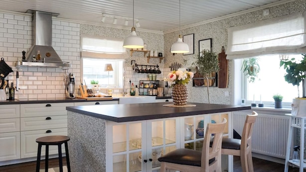 A kitchen with a central island, white cabinetry, and a hanging light fixture. - 4 Star Holiday Home in Kungshamn (Kungshamn)
