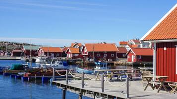 A harbor with red buildings, boats, and a wooden pier.