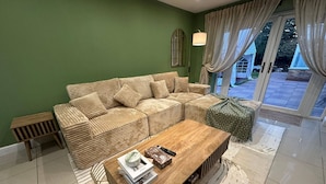 A living room with a sofa, a coffee table, and a patterned rug.