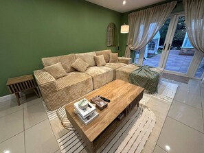 A living room with a sofa, a coffee table, and a patterned rug. - Stylish 2 Bed Flat Parking Sutton Coldfield (Sutton Coldfield)