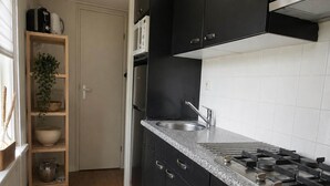A kitchen with black cabinets, a granite countertop, a stainless steel sink, and a microwave. - Vechtdal Chalet de Berk (Rheezerveen)