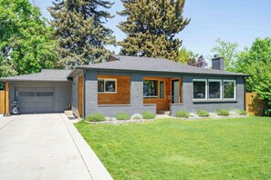 Ein modernes, zweistöckiges Haus mit Garage, Eingangstür und gepflegtem Rasen.