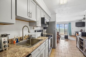 Eine moderne Küche mit Einbauofen, Spüle und Kühlschrank.