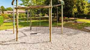 A playground with swings and a climbing structure. - Spacious Provencal Maisonette Escape (Les Mathes)