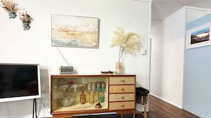 Una habitación con un armario de madera, un televisor y un cuadro en la pared.