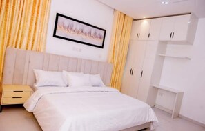 Ein Schlafzimmer mit Bett, Nachttisch, Kleiderschrank und einem gerahmten Bild an der Wand.