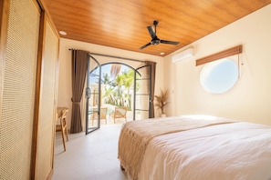 A bedroom with a bed, a ceiling fan, a window, and a view of the outdoors. - Disenta Villa by Tasvan (Badung)