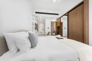 A modern bedroom with a bed, a desk, and a wardrobe. - Free Housekeeping Visits During Your Stay - Stayshort - Studio in Jumeirah Village Circle for 2 With Balcony (Dubai)