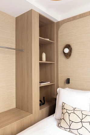 A bedroom with a built-in wardrobe, a bedside table, a bed with white bedding, and a wall-mounted light fixture. - Elegant Apartment a/c - 1BR /4P - Champs de Mars (Paris)