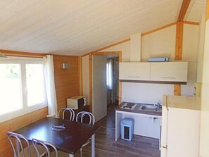 Una cuina compacta amb zona de menjador, microones, rentapelats i armaris.
