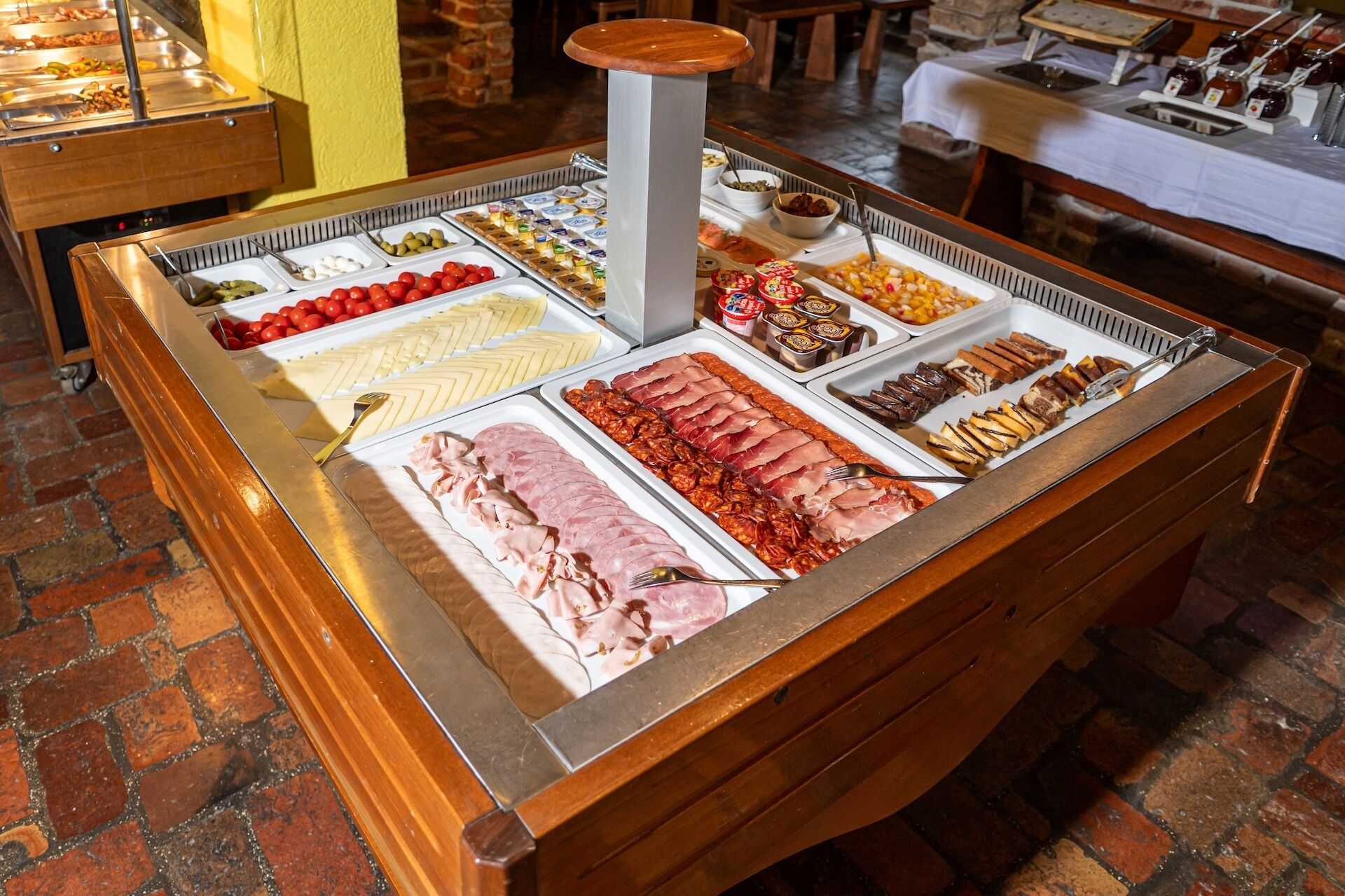 Un buffet proposant une variété de plats, notamment des viandes, des fromages et des fruits.