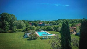 Una propiedad residencial con piscina, césped y vistas del paisaje circundante.