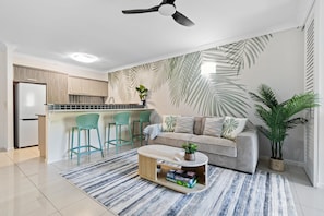 Una cocina moderna con una isla integrada, taburetes de bar y un ventilador de techo.