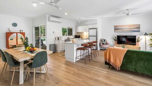 Een moderne open woonruimte met een eethoek, keuken en zithoek.
