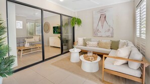 Ein modernes Wohnzimmer mit Sofa, Couchtisch und einer hängenden Pflanze.