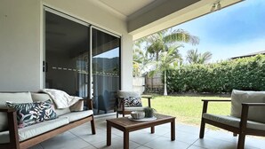 A patio with a sofa, chairs, and a table. - The Nook - Pet Family-friendly 4-bedroom (Cairns)