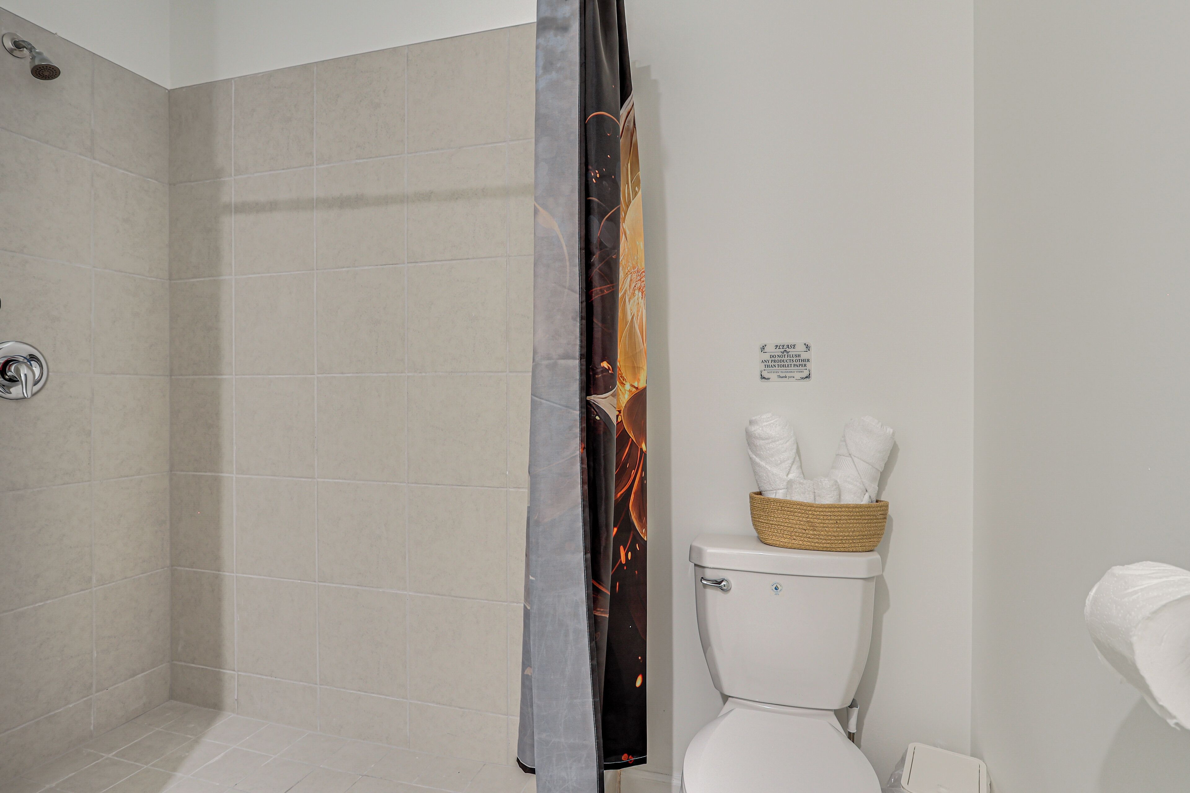 Une salle de bain équipée d’une douche, de toilettes et d’un porte-serviettes avec des serviettes.