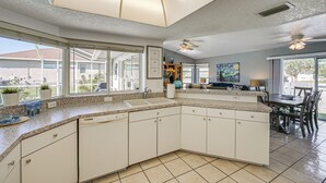 A spacious kitchen with a large island, built-in appliances, and a view to the outside. - Walk to Port Charlotte Beach Park! Canal-front Gem (Port Charlotte)