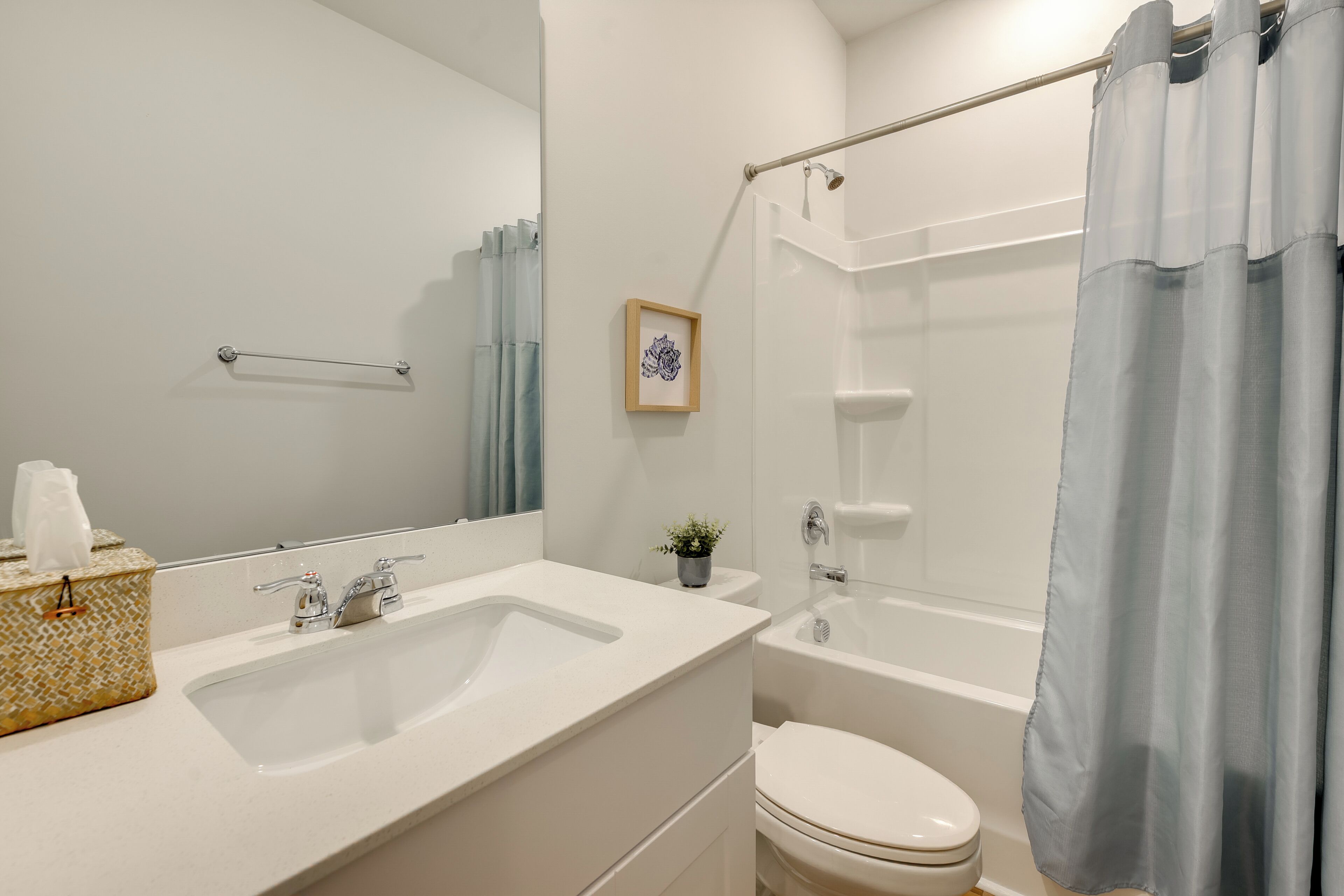Un baño con lavamanos, inodoro y ducha.