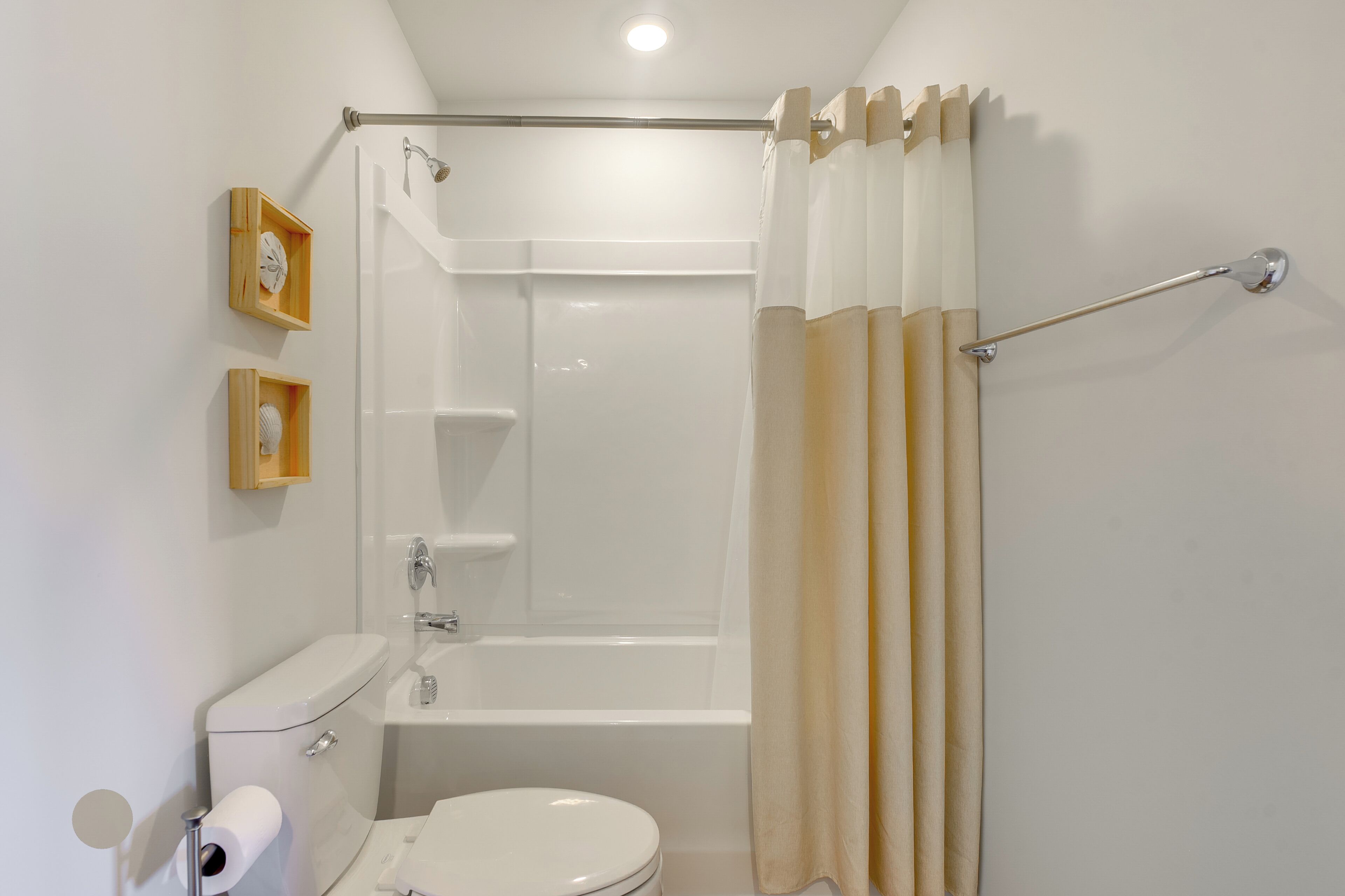 A bathroom with a toilet, a bathtub, and a shower curtain.