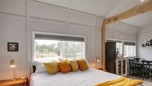 A bedroom with a large bed, a window, a desk, and a chair. - 6 Mi to Lake Pend Oreille! Cozy Cabins w/ Views (Athol)