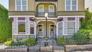 A two-story Victorian-style house with a front porch, a stone staircase, and a decorative fence. - Historic Home in Downtown Sonora! (Sonora)