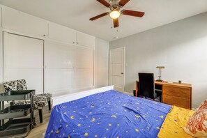 Une chambre à coucher avec un lit, un bureau, une chaise et une armoire.