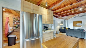 A modern kitchen with wooden cabinets, a stainless steel refrigerator, and a wooden dining table. - Fishing Dock & Mtn Views! Buchanan Lake Family Gem (Burnet)